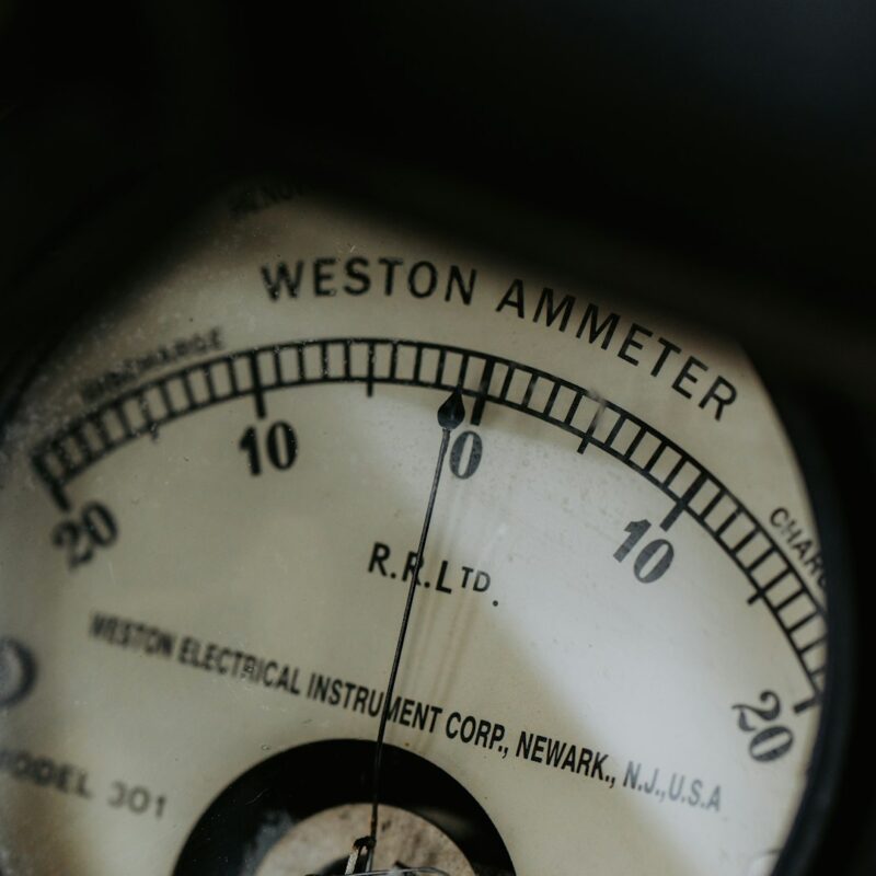 Analog ammeter needle resting at zero on a scale marked in both directions
