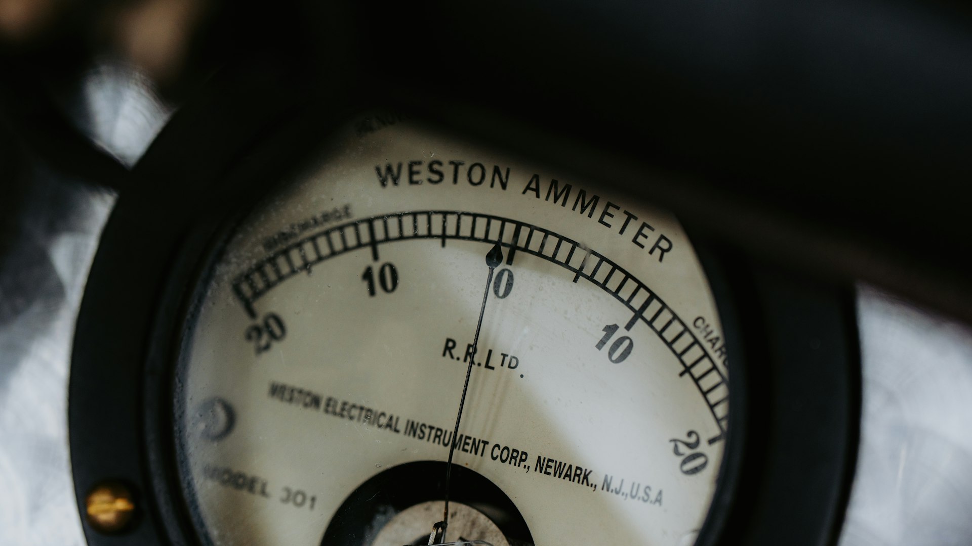 Analog ammeter needle resting at zero on a scale marked in both directions